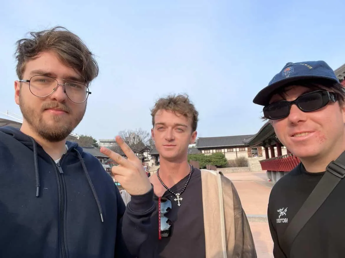 Ksawery with two travellers he met in Seoul, in front of a Korean palace